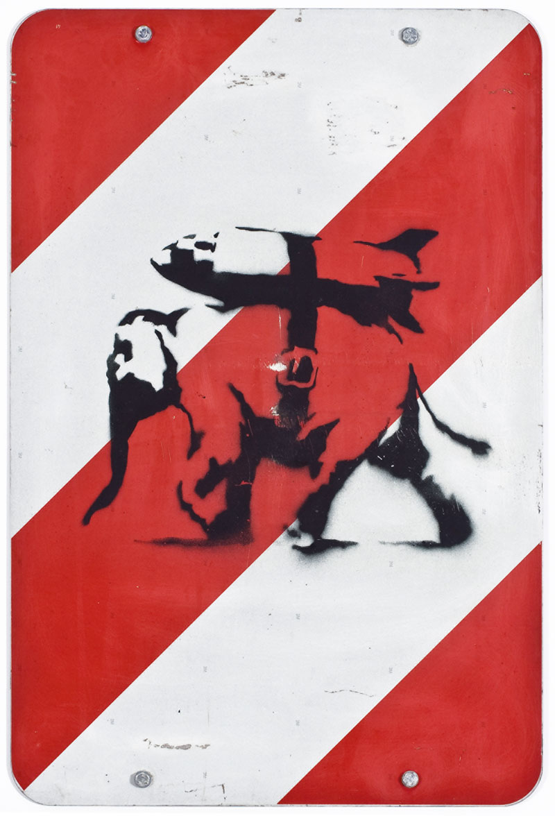 A destra: Banksy- Heavy weaponry 2002, stencil e spray su cartello stradale, 74x50 cm. Collezione Reinking, Amburgo ©